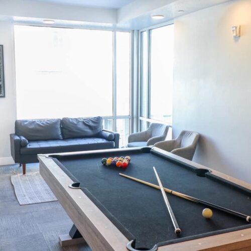 Promenade apartment community game room with pool table
